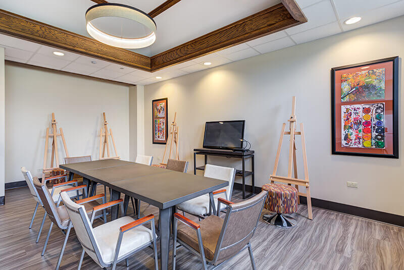 Arts and crafts studio with easels, tables, and chairs for resident creative activities at Amazing Grace Senior Living