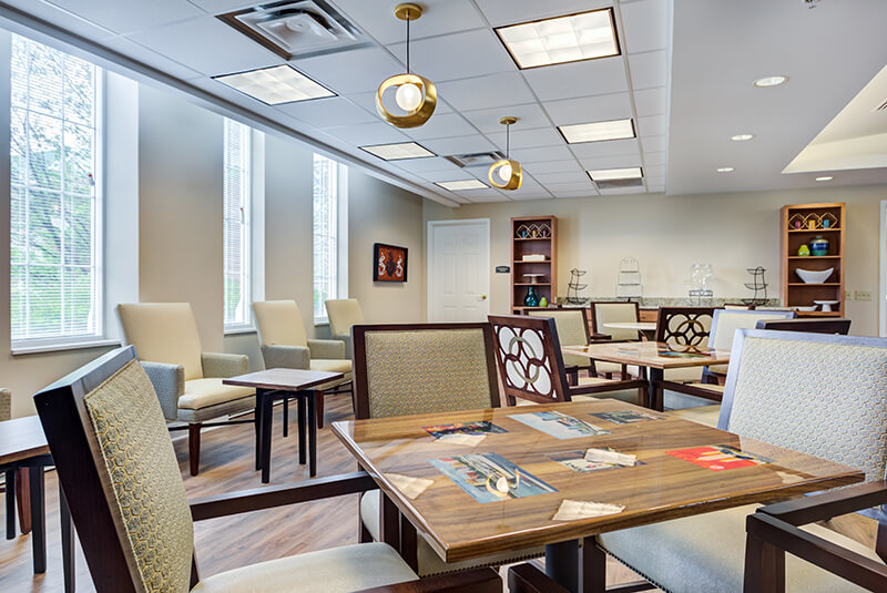 Bright bistro dining space with natural light and social seating at Amazing Grace Senior Living