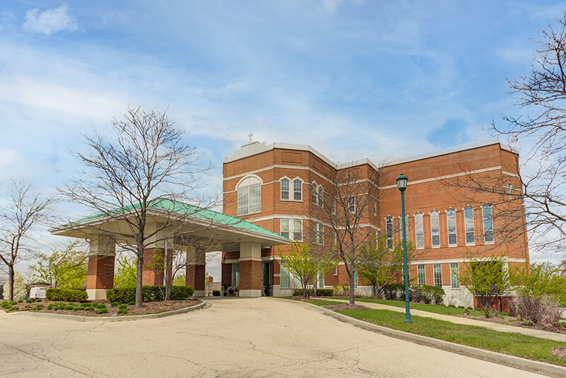 Front exterior of Amazing Grace Senior Living with brick facade and covered entrance