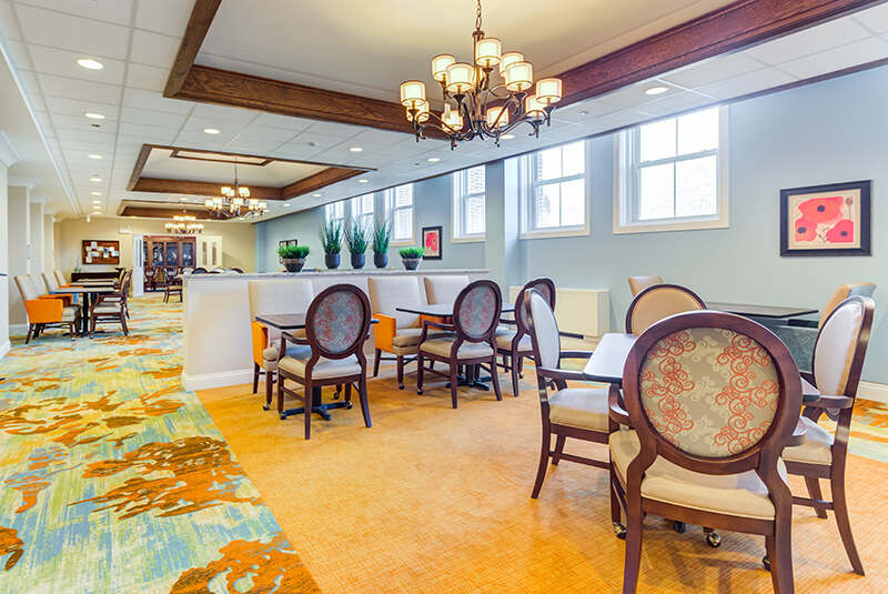 Elegant dining room with chandeliers and spacious seating at Amazing Grace Senior Living