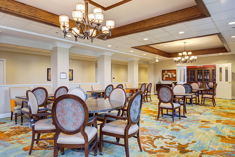 Large dining space with decorative lighting and comfortable chairs at Amazing Grace Senior Living