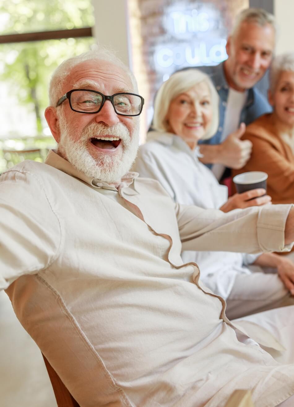 Happy senior residents laughing and enjoying social time together at Amazing Grace Senior Living