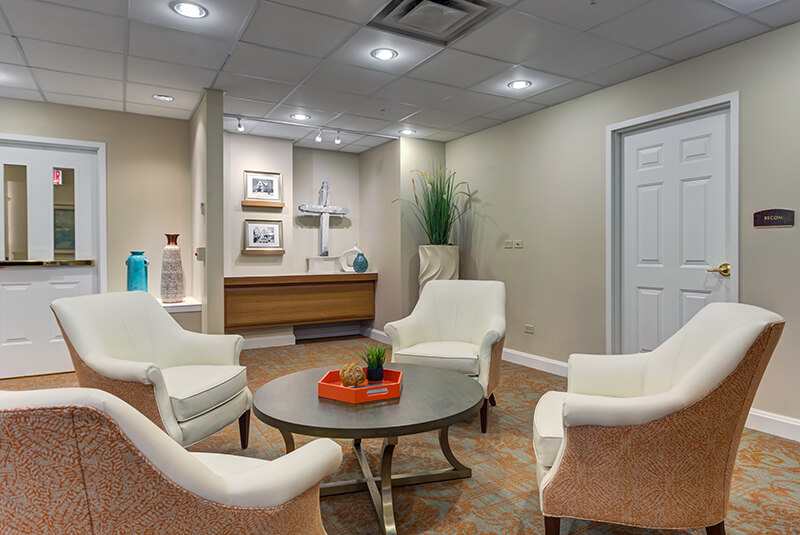 Bright memory care hallway with decorative touches and display shelves at Amazing Grace Senior Living