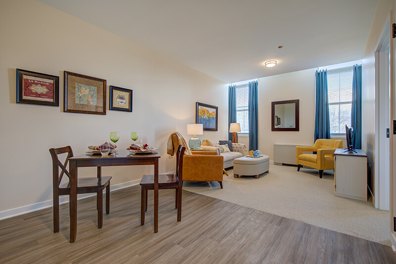 One-bedroom apartment kitchen and living room with modern cabinets and decor at Amazing Grace Senior Living