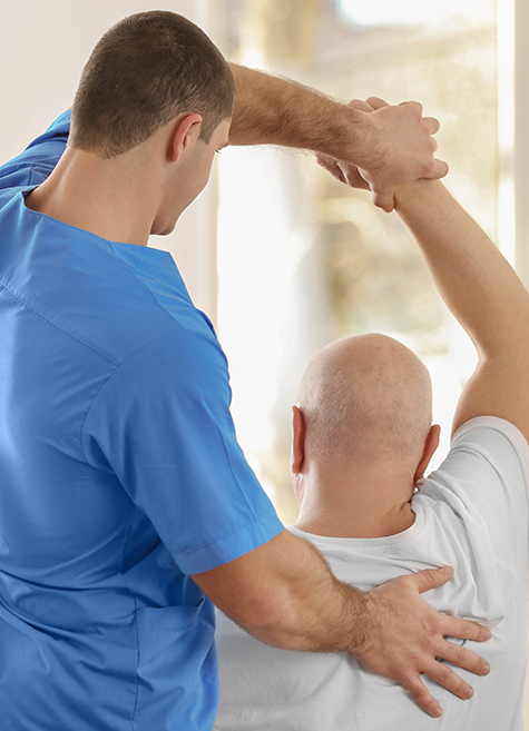 Physical therapist assisting senior resident with mobility exercises at Amazing Grace Senior Living