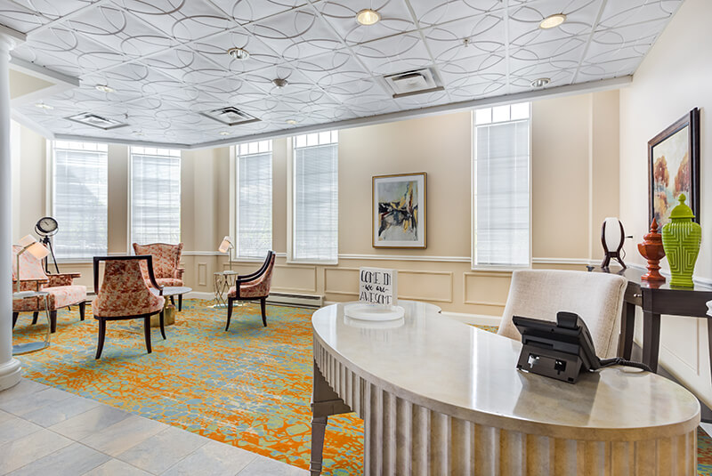 Reception area with front desk and seating for guests at Amazing Grace Senior Living