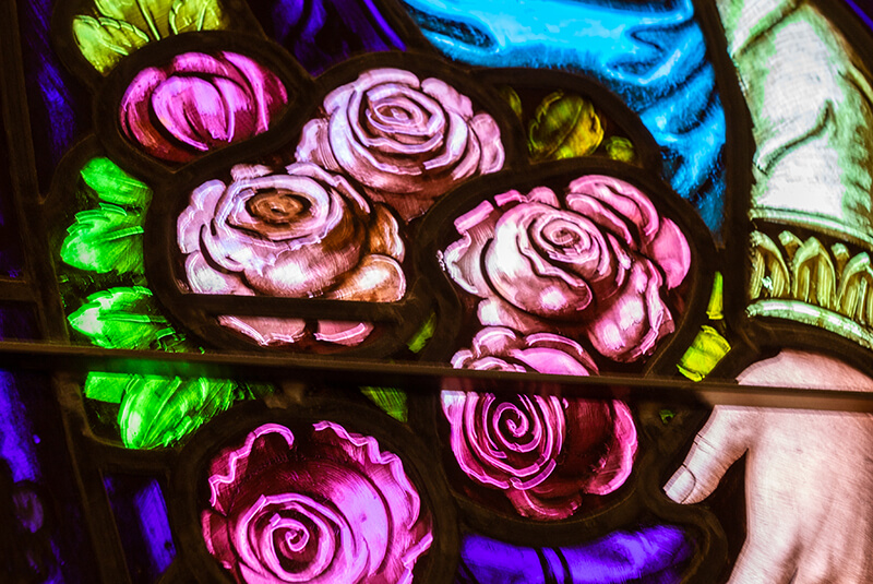 Close-up of pink roses in stained-glass window artwork at Amazing Grace Senior Living
