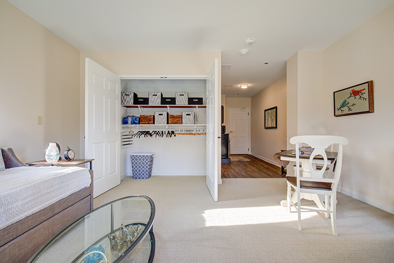 Apartment closet and dining area view inside a studio at Amazing Grace Senior Living