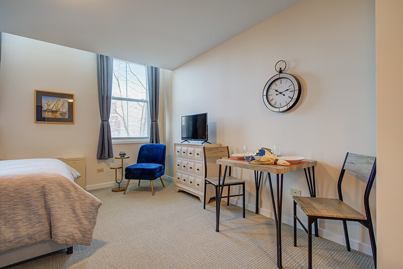 Cozy studio dining nook with table and chairs near the bedroom area at Amazing Grace Senior Living
