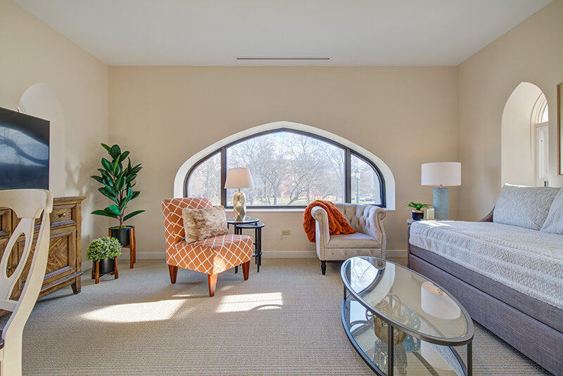 Cozy sitting area with natural light and modern furnishings in a studio apartment at Amazing Grace Senior Living