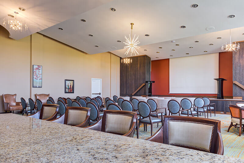 Auditorium with rows of chairs and a stage for resident events and performances at Amazing Grace Senior Living