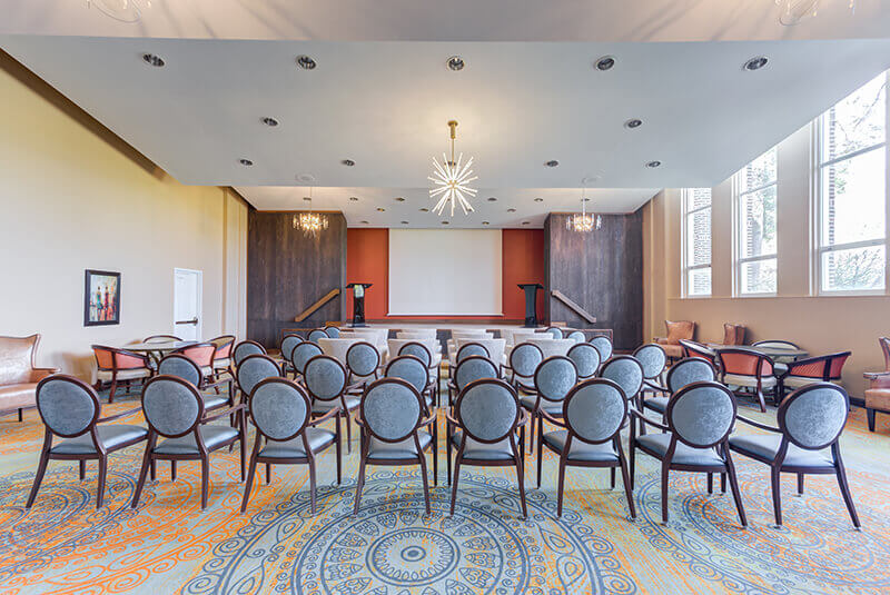 Theater-style auditorium with stage, chairs, and modern lighting at Amazing Grace Senior Living